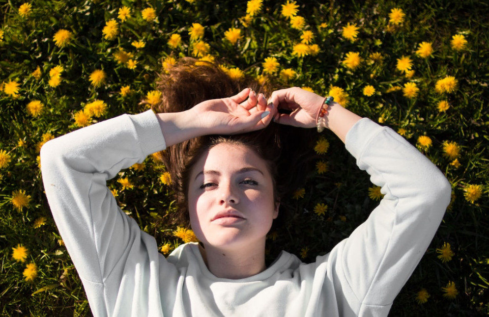 What is visualization technique? Woman lying on grass daydreaming