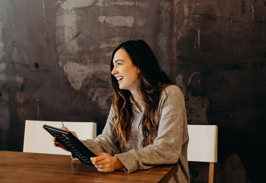 the best manifesting techniques - a woman is holding a notebook 