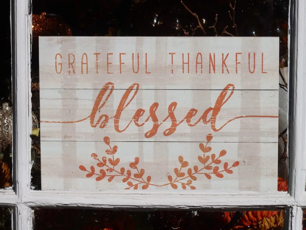 how to be thankful for what you have: the word "blessed" carved on a wood piece