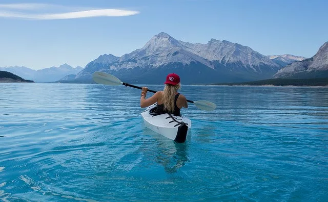 summer bucket list ideas: a woman is kayaking