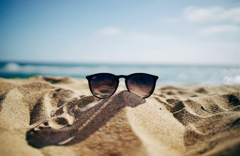 Summer Bucket List Ideas: a sunglasses on a beach