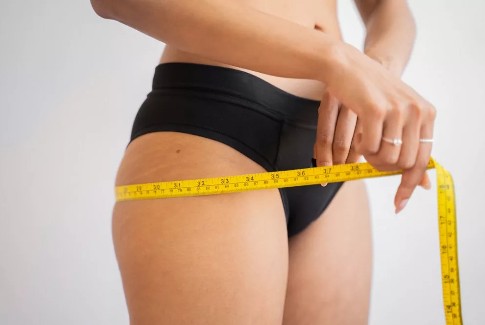 How to lose stomach fat in 3 days:a woman is measuring her body