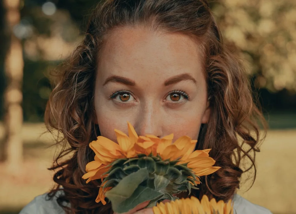 5 ways to boost your self confidence instantly: a woman is smelling a flower