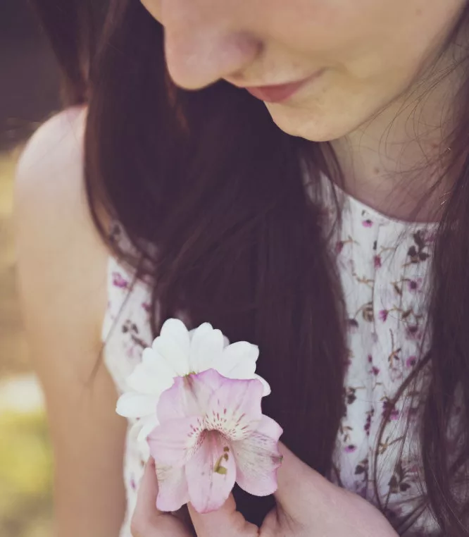How to practice mindfulness for beginners: a woman is looking at a flower