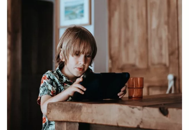 Teaching mindfulness for children: a child is look at a tablet