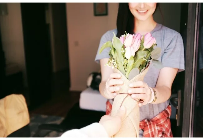 how to start gratitude journaling: a man is giving flowers to a woman
