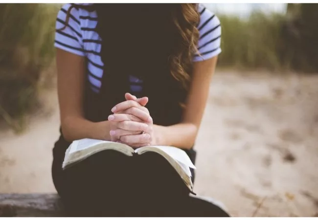 What does the Bible say about the Law of Attraction? a woman is praying